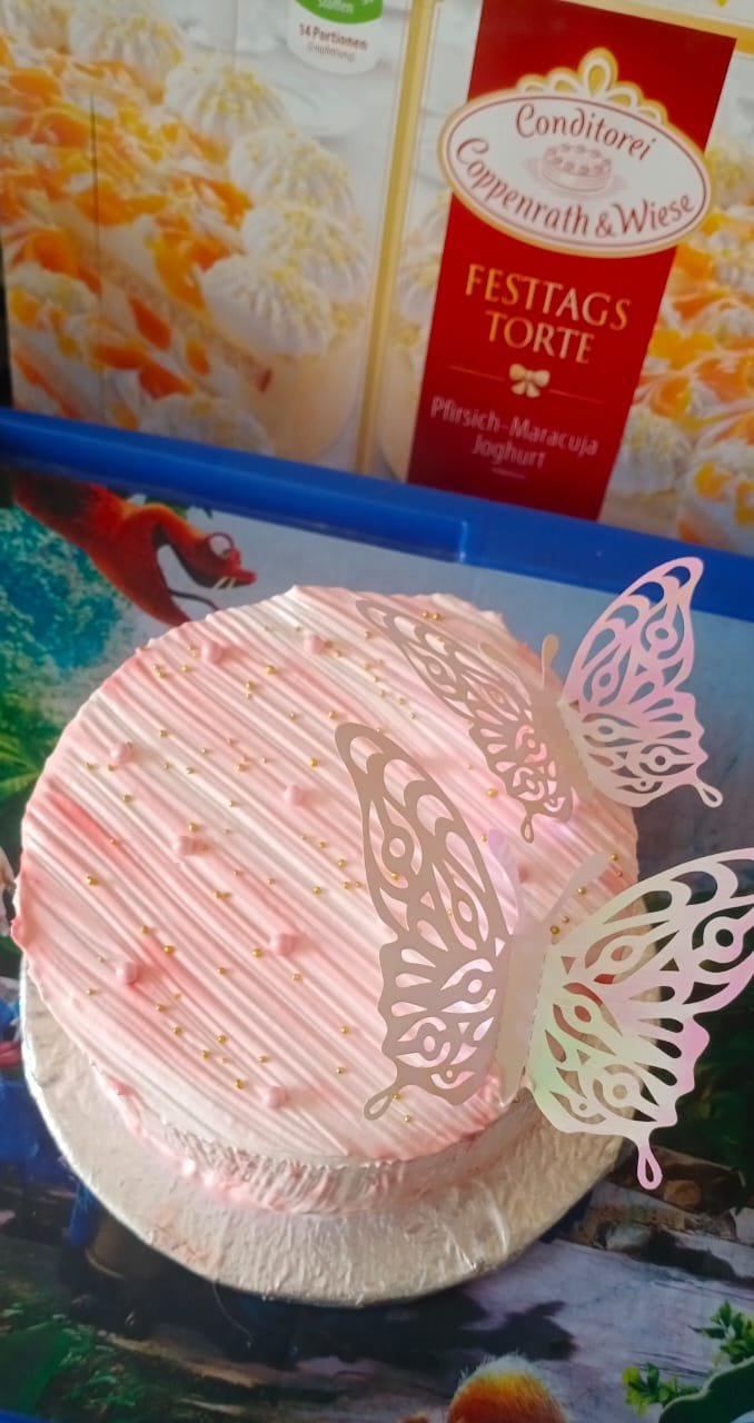 Soft pink cake with a cluster of pastel laser-cut butterfly decorations