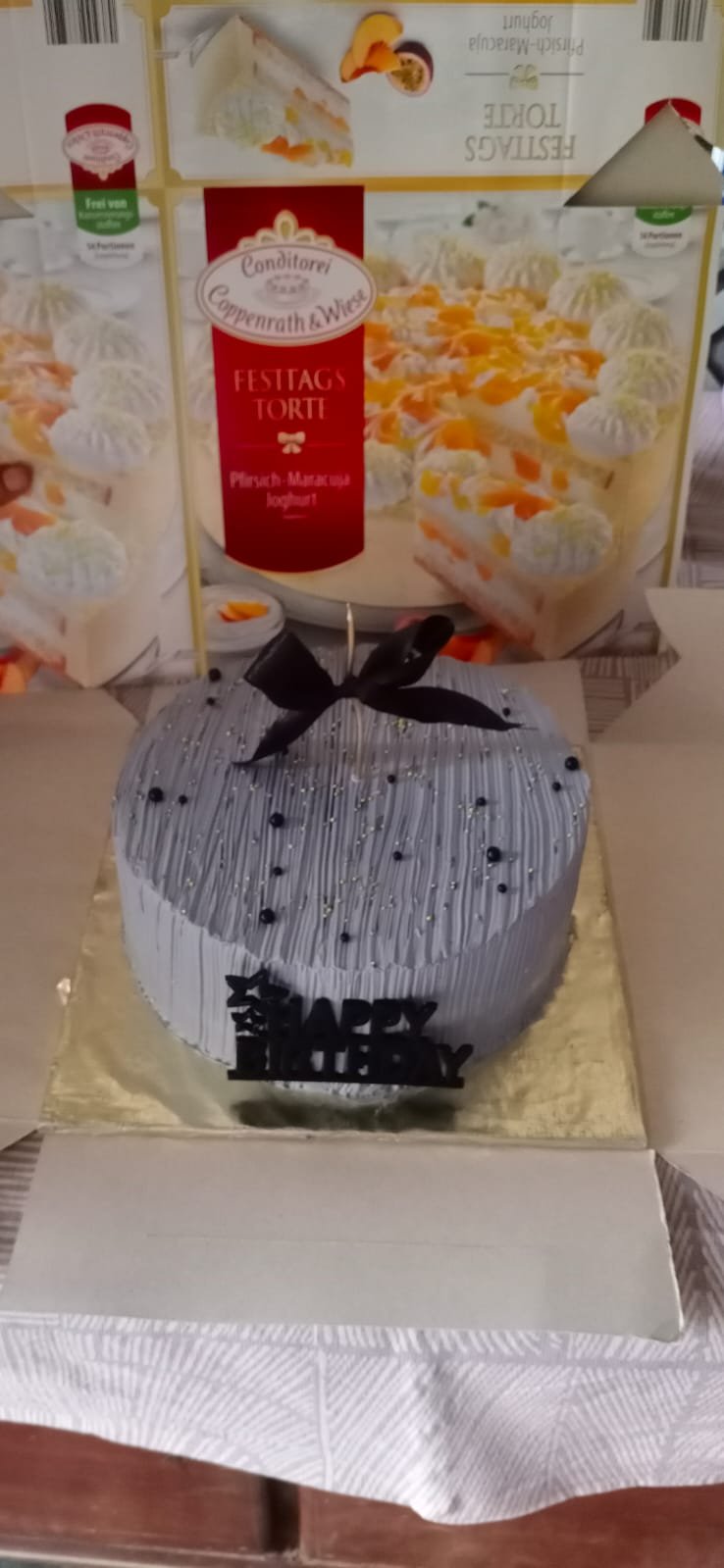 Lavender-grey textured buttercream cake with a black satin bow and birthday topper