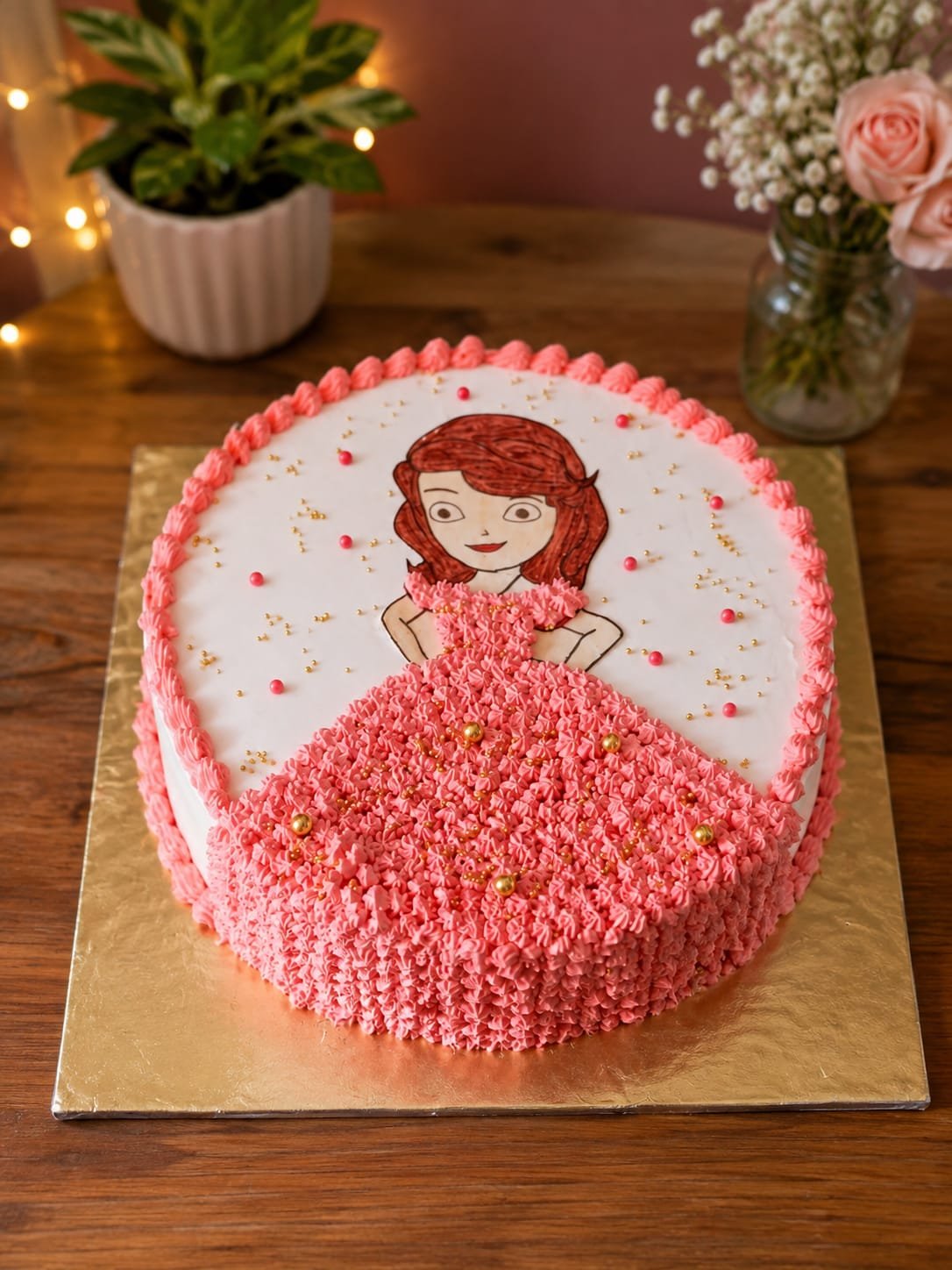 White cake with a printed princess topper and a hand-piped pink buttercream rosette dress
